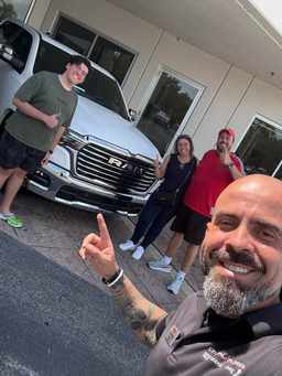 Cliente satisfeito com a compra do carro nos EUA, ao lado do David